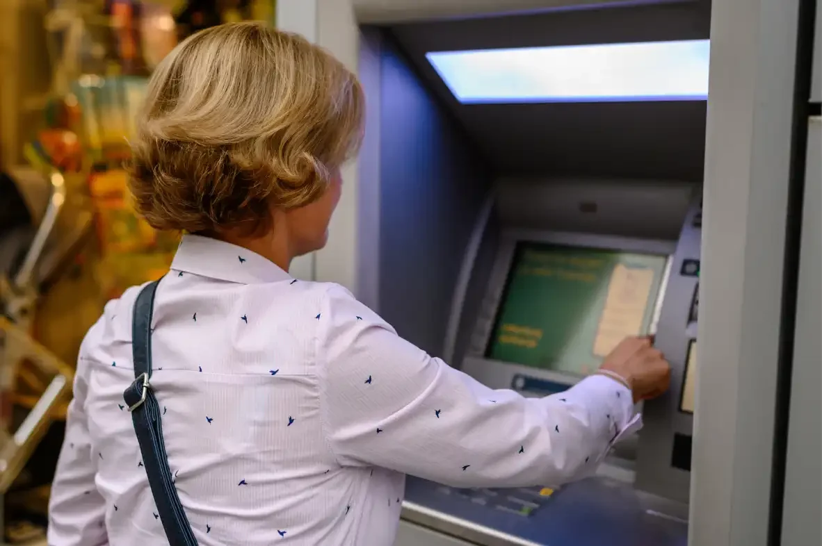 lady withdrawing cash abroad at ATM, saving ATM fees